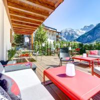 a patio with tables and chairs and mountains in the background at Hotel Lün, Brand