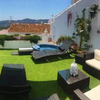 a backyard with a green yard with a couch and chairs at Casa Rural Miller's of Frigiliana