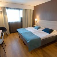 a hotel room with a bed with blue pillows at Hotel Kivitasku, Kaarina