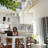 a woman sitting at a table with a laptop at Thalia Hotel, Kamena Vourla