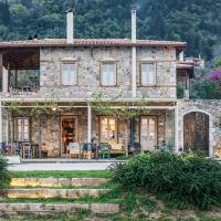 a stone house with a table and chairs in front of it at Mazaraki Guesthouse, Mystras