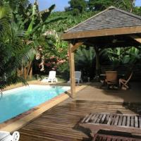 a wooden deck next to a swimming pool with a gazebo at Villa Maora, Kangani