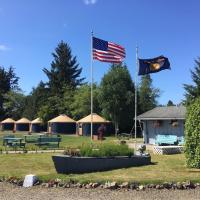 two flags flying in a park with tents in the background at Tillamook Bay City RV Park
