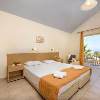 a bedroom with a large bed and a large window at Olympion Village, Kavos