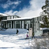 a house in the snow with people in front of it at Elk at Falls, Falls Creek