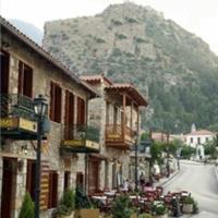 a street with buildings and a mountain in the background at Mystras Inn
