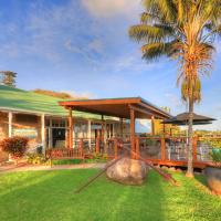 a house with a porch and a palm tree at Castaway Norfolk Island, Burnt Pine