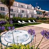 a courtyard with a hot tub and chairs and purple flowers at Mareta View - Boutique Bed & Breakfast, Sagres
