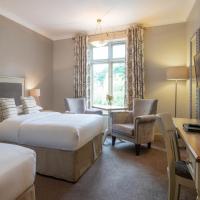 a hotel room with two beds and a desk at Kilkenny River Court Hotel