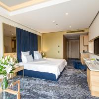 a hotel room with a bed and a kitchen at Swissotel Sarajevo