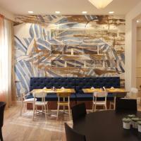 a dining room with tables and chairs and a mural at Best Western Hotel Piemontese, Bergamo
