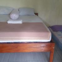 a small bedroom with two beds in it at Pedek Homestay, Praya