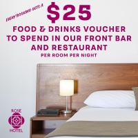 a bedroom with a bed and a table with a lamp at The Rose Hotel & Motel, Bunbury