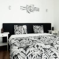 a bedroom with a black and white bed with pillows at Pirata hostel Milfontes, Vila Nova de Milfontes