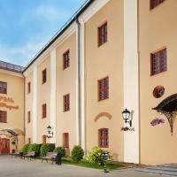 a large building with benches in a courtyard at Hotel Monastyrski Minsk City Centre