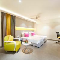 a hotel room with a bed and a yellow chair at ZIBE Salem By GRT Hotels