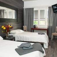 a hotel room with two beds and a television at Hotelli & Ravintola Martinhovi, Raisio