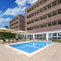a swimming pool in front of a building at Best Western Plus Hotel Farnese, Parma