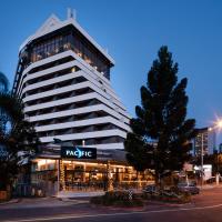 a large white building with a mhap sign on it at Pacific Hotel Brisbane
