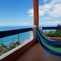 a hammock on a balcony with a view of the ocean at Orrie's Beach Bar and Hotel, Crab Hill