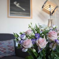 a vase filled with pink roses and purple flowers at Hotel Abrial, Cannes