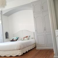 a white bedroom with a white bed with two pillows at La Maison Blanche, Blaye