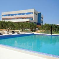 a large swimming pool with lounge chairs and a building at Hotel Panorama, Šibenik