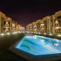 a large swimming pool in a courtyard at night at Faris Villas, Al Khīrān
