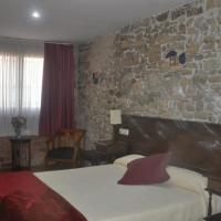 a bedroom with a stone wall and a bed in a room at Don Pedro, Avilés