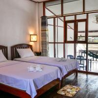 a bedroom with two beds and a large window at Dokchampa Guesthouse, Don Khone