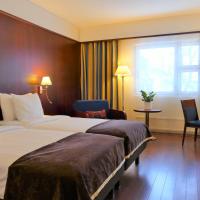 a hotel room with two beds and a desk at Hotel Kalliohovi, Rauma