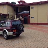 a maroon jeep parked in front of a house at International Hotel, Yaoundé