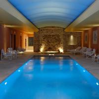 a swimming pool in a hotel with a fireplace at Auberge de Cassagne & Spa, Le Pontet
