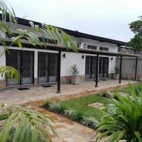 an exterior view of a white house with black gates at Urban Lodge, Bujumbura