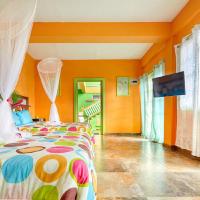 a bedroom with orange walls and a bed with a colorful bedspread at Villa Des Pitons, Soufrière