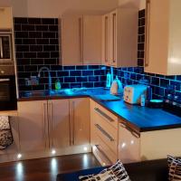 a kitchen with blue tiles on the walls and cabinets at 'Park House', Chorley