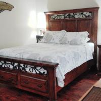 a bedroom with a large bed with a wooden headboard at Los Gatos Garden Inn Hotel