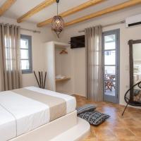 a bedroom with a large white bed and a mirror at Ampelos Inn, Agios Prokopios
