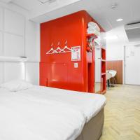 a room with a bed and a red wall at Omena Hotel Helsinki L&ouml;nnrotinkatu