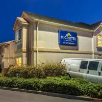 a minivan parked in front of a building with a sign at Microtel Inn & Suites by Wyndham Auburn