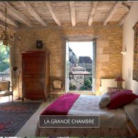 a bedroom with a large bed and a living room at La Source, Beynac, Dordogne, Beynac-et-Cazenac