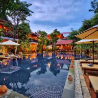 a pool at a hotel with tables and umbrellas at Mane Village Suites, Siem Reap