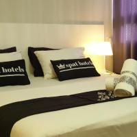 a bed with black and white pillows on it at Spat Hotel Ashdod