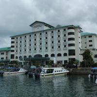 a large building with boats docked in the water at Seafest Hotel, Semporna
