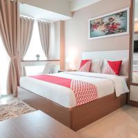 a bedroom with a large bed and a mirror at OYO Flagship 755 Appartel Grand Dhika City, Bekasi