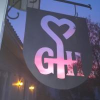 a sign hanging from a building with a srt sign at Gasthaus Henri, Raisio