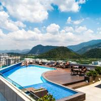 a swimming pool on top of a building with mountains at Américas Barra Hotel, Rio de Janeiro
