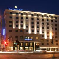 a building with a sign on top of it at night at Hotel Golden Tulip Varna, Varna City
