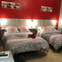 a bedroom with two beds and a red wall at Hotel des Remparts, Villeneuve-sur-Lot
