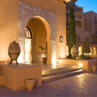 a building with an arch and stairs in a courtyard at Alhambra Thalasso, Hammamet